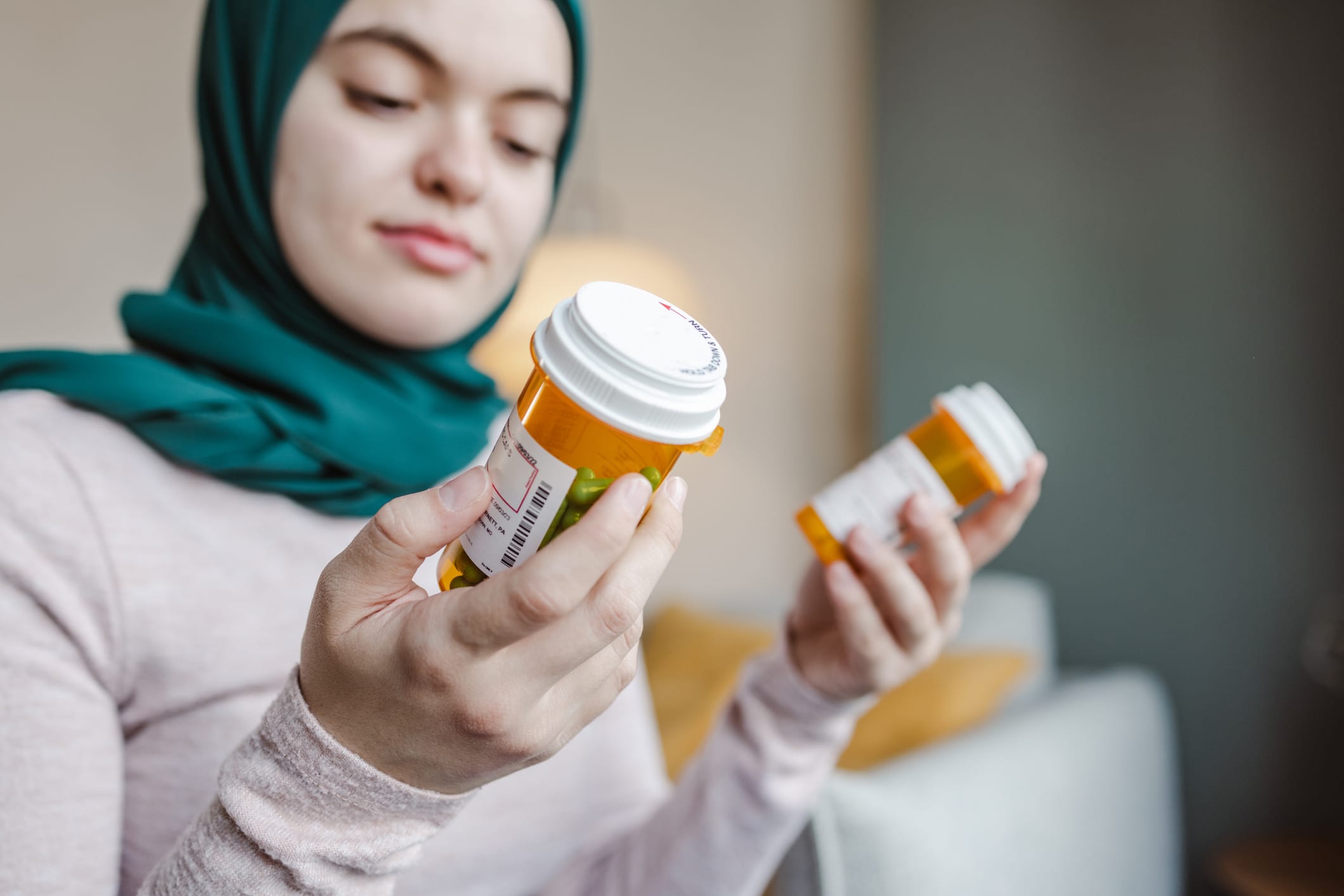 Woman comparing two bottles of prescription medication