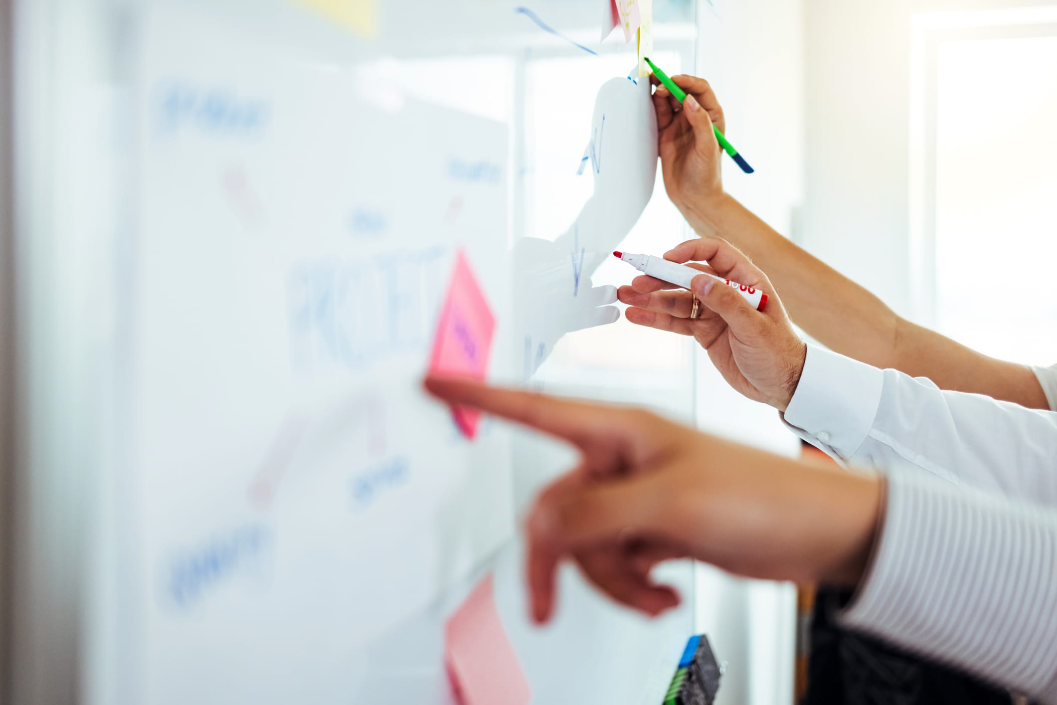 Closeup shot of an unrecognizable businessman writing notes on a whiteboard in an office