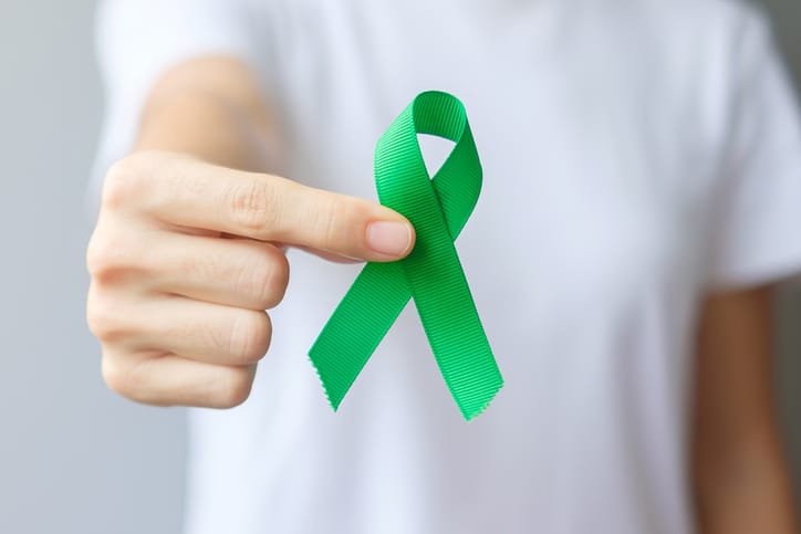 Man holding green awareness ribbon