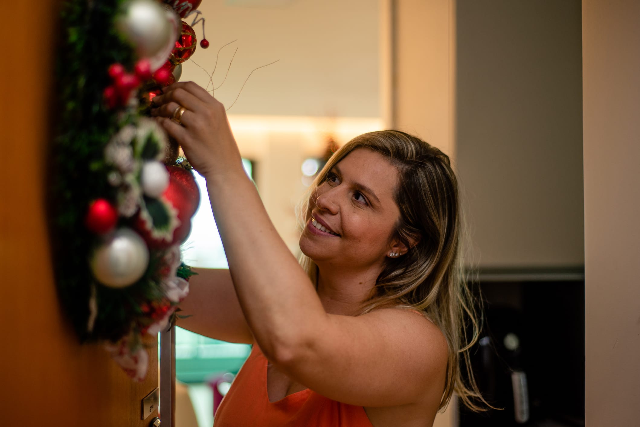 Woman decorates door with Christmas wreath. christmas decorations. garland.