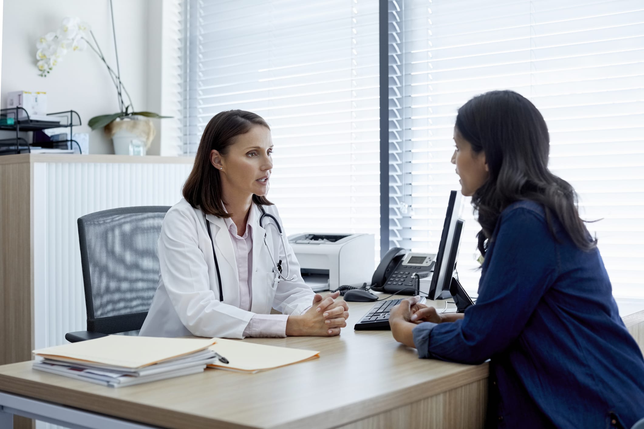 Doctor and patient sitting at desk talking