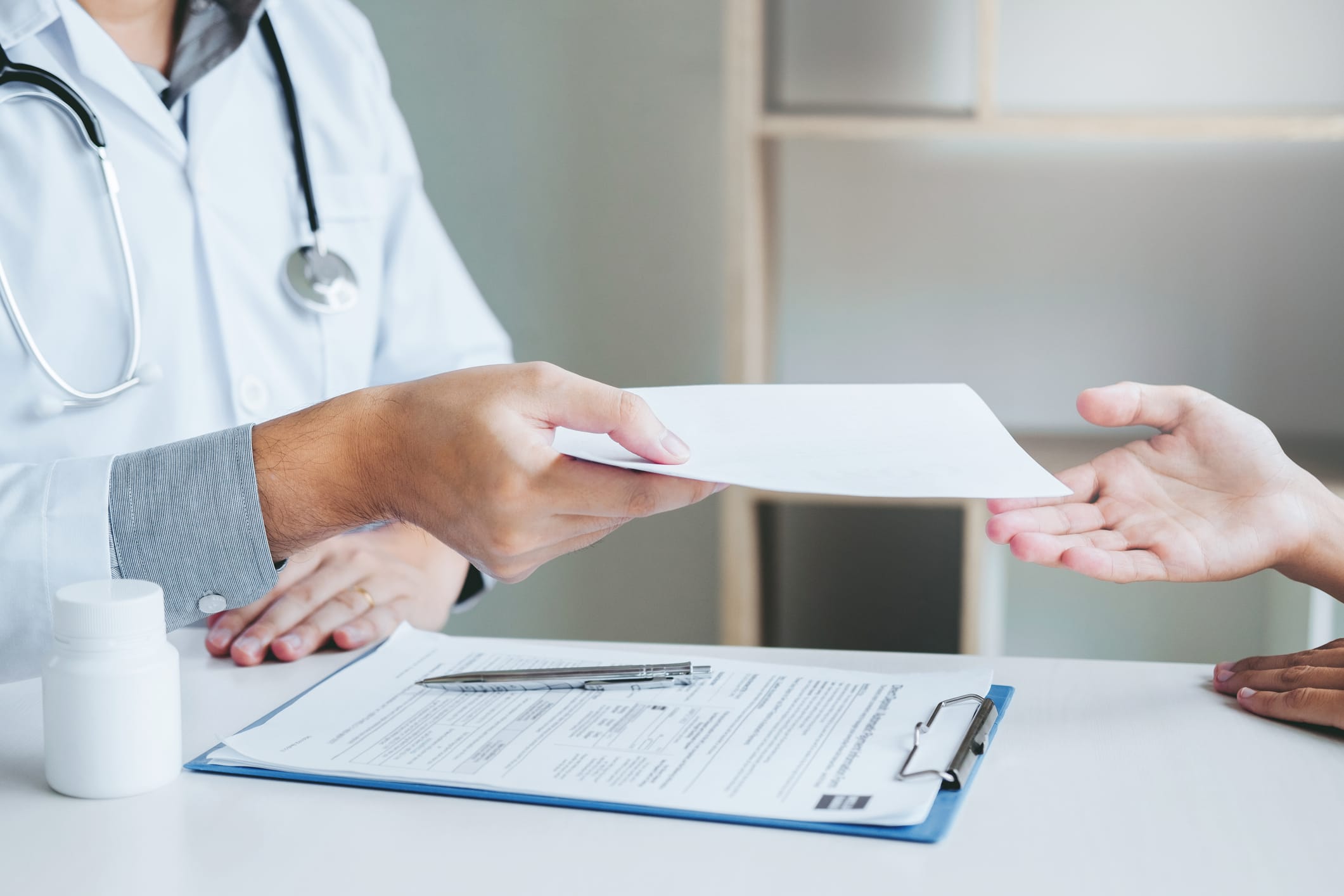 Doctor or physician handing paper to female patient