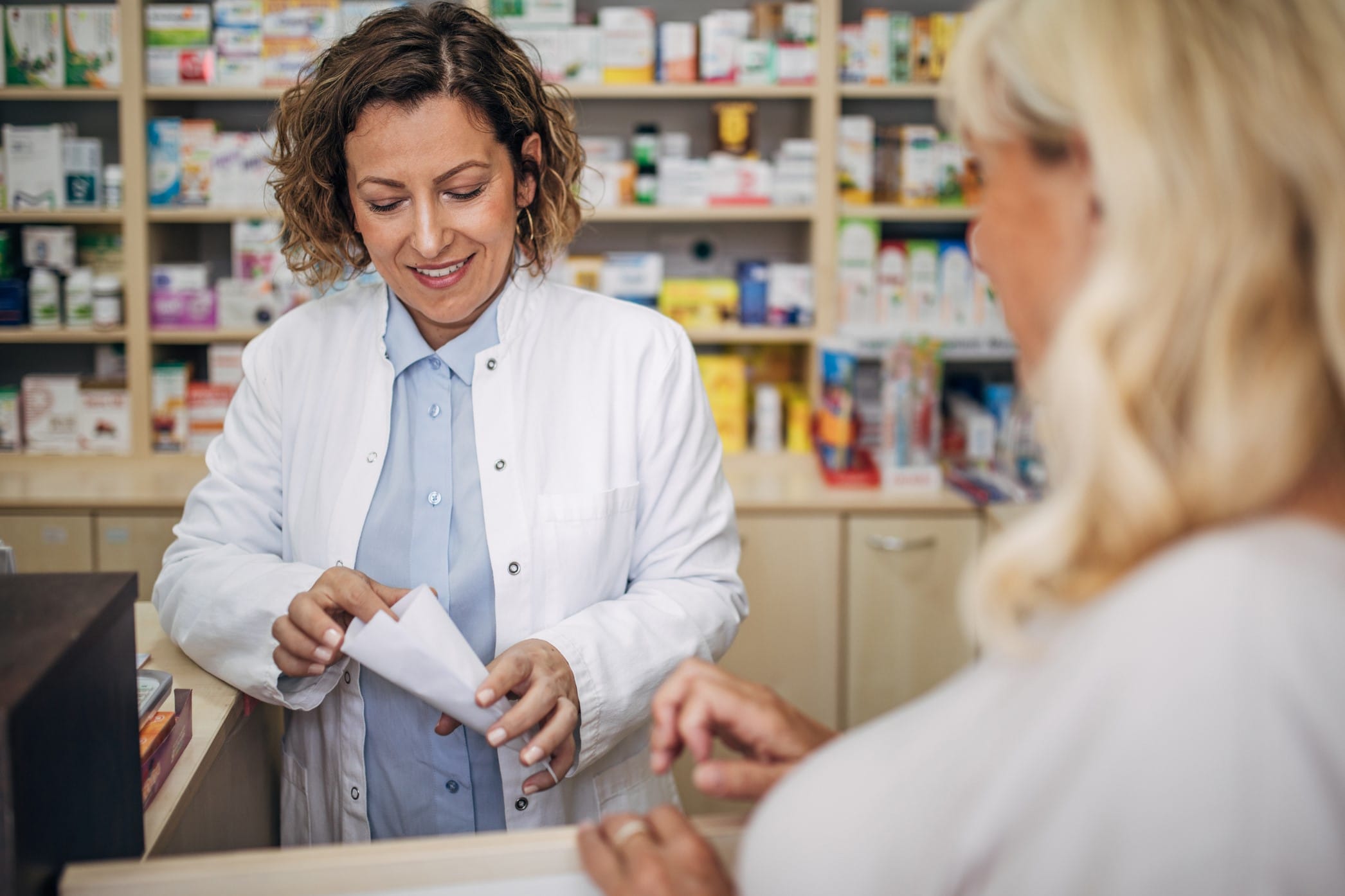 Pharmacist filling prescription for a patient