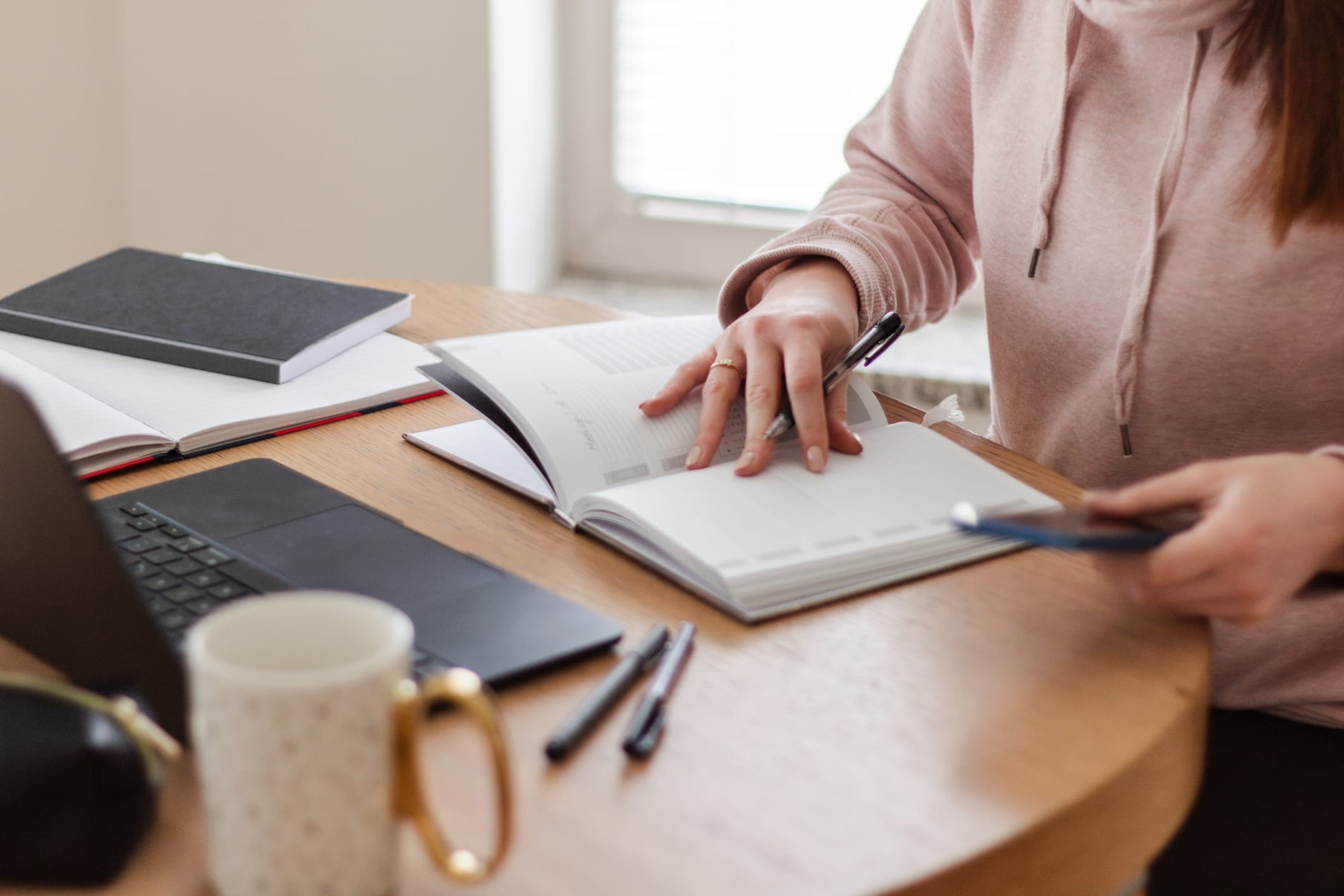 Close-up of woman writing in her planner