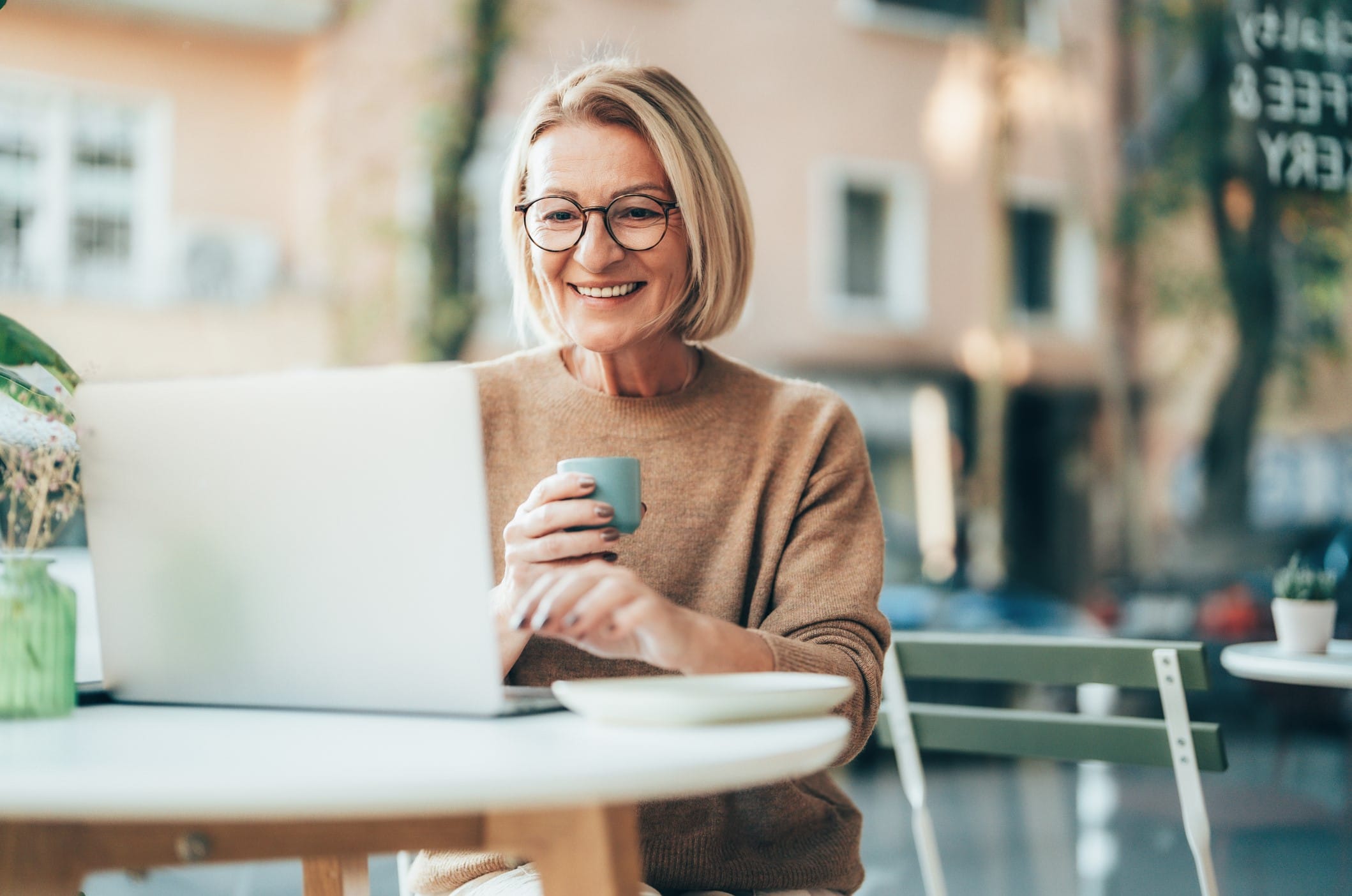 Older woman on laptop in cafe